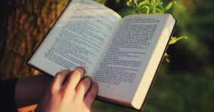 Open book held outdoors in nature